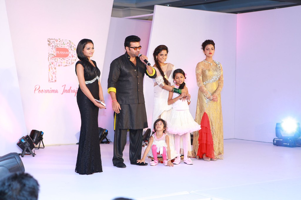 Hosts, designer and children on stage in front of the Pranaah identity backdrop